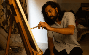 Painter working on an easel indoors