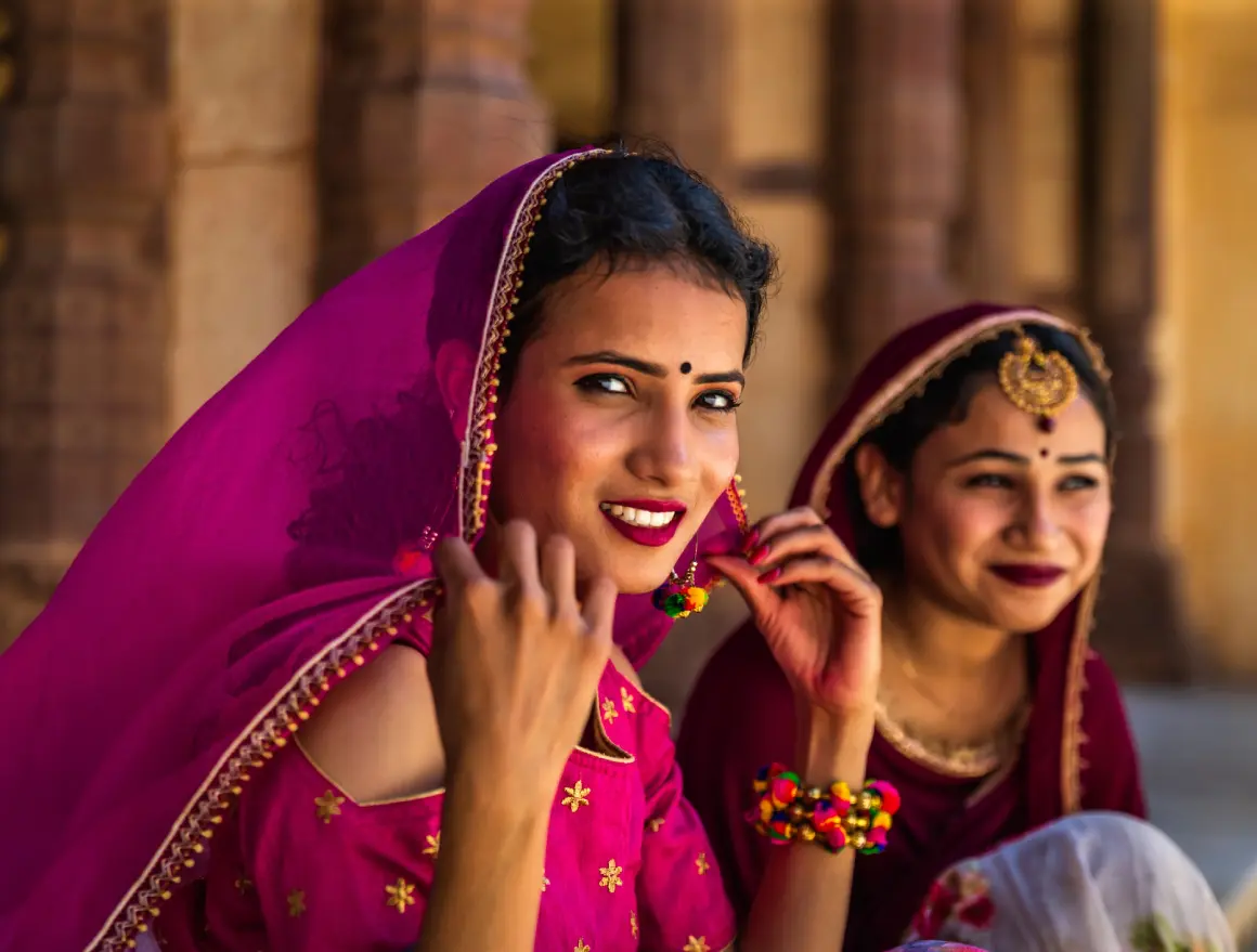 Women in traditional attire smiling