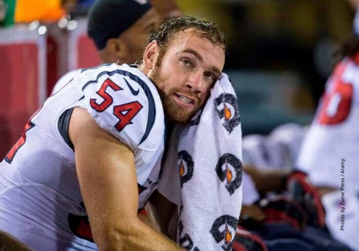Football player resting on the sidelines.